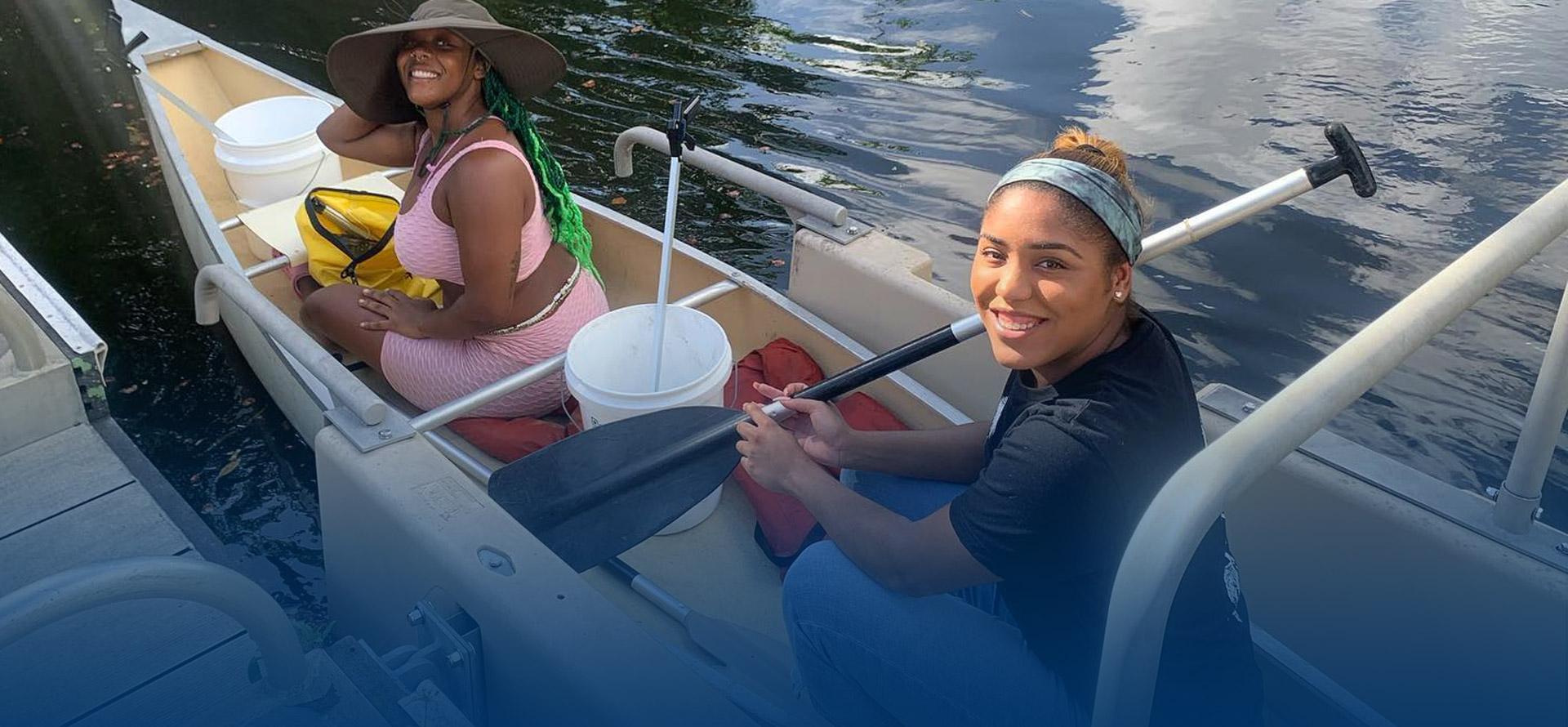 Two Women doing clean up in a canoe